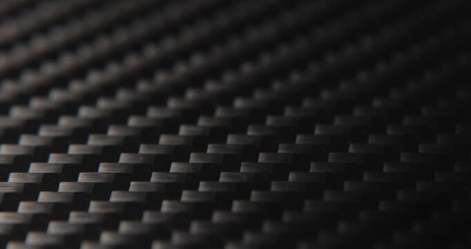 Close-up slide over the real carbon fiber texture background. 