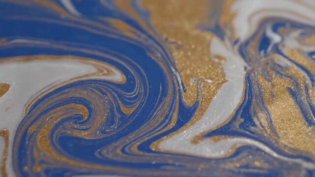 Abstract Swirling Blue Gold and White Liquid Paint Macro Shot.