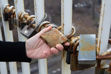 Woman hand holding old rusty padlock