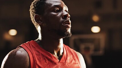 Focused male basketball player sweating intensely on court, showcasing determination and athletic effort during a game