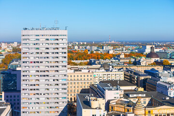 Obraz premium Warsaw city skyline shows mix of residential towers and historic buildings. Prominent modern tower block dominates the left side of the frame