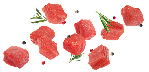 Fresh raw beef pieces, rosemary and peppercorns flying on white background