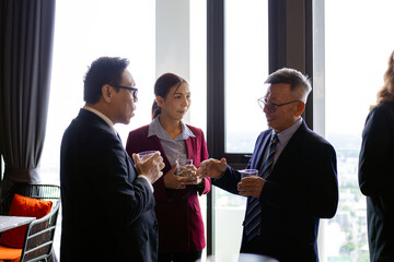 Group of business professionals talking and networking during corporate event in high-rise office, representing professional communication, leadership, and workplace connection