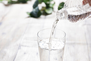 ペットボトルの水をグラスに注ぐ Pouring bottled water into a glass in a bright interior