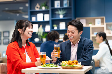 飲食店でビールを飲むミドルのカップル