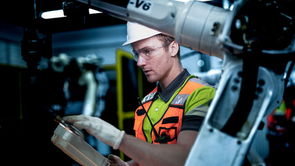 An engineer works on an AI robotic arm, representing the future of work. This advanced...