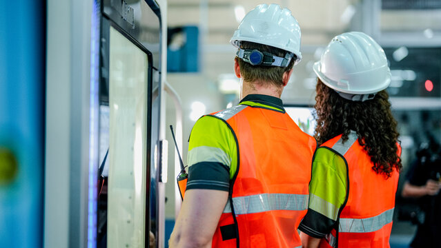A team of engineers uses an AI-driven smart factory for advanced manufacturing. This future of work technology optimizes the supply chain and production efficiency for high-tech growth.