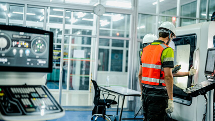 Three engineers program an industrial robot or 5-axis CNC machine using an AI interface. The team manufactures advanced microchips or high-tech components in a smart factory.