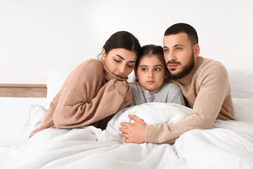 Frozen family under blanket with lack of heating in bedroom