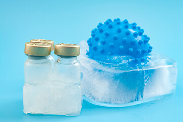 Frozen Vaccine Storage Concept with Medical Vials and Virus Model in Ice on Blue Background