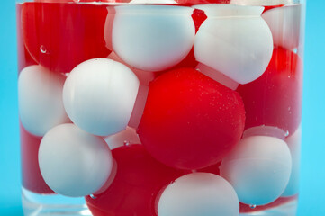 Water Molecule Model Concept with H2O Chemistry Atom Link Toy in Beaker of Water on Blue Background