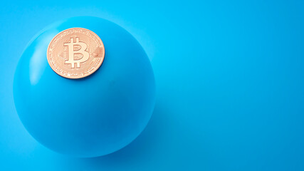 Crypto currency bubble, hazardous trading and  stock exchange crisis concept with bitcoin and balloon about to burst isolated on blue background with copy space