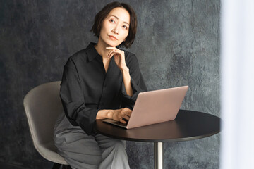 テーブルでラップトップを操作する女性　ライフスタイルイメージ