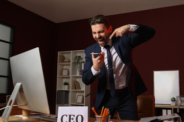 Angry businessman shouting at mobile phone in office