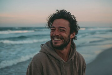 Happy man smiling on beach at sunset