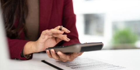 Close up of woman accountant using calculator to calculate tax refunds or  finance. woman doing...