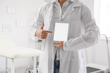 Female physiotherapist pointing at blank tablet computer in office