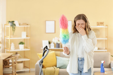 Young woman suffering from dust allergy while cleaning flat