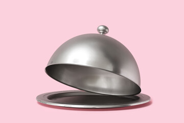 Silver tray with open cloche on pink background © Pixel-Shot