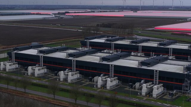 Close up aerial drone video of emergency backup generators at a large redundant data center in Middenmeer, The Netherlands, supporting big data storage, AI infrastructure,high performance computing.