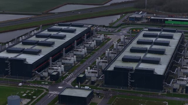 Aerial drone video of a large redundant colocation data center in Middenmeer, The Netherlands, showcasing massive data processing, storage capacity, and advanced AI computing infrastructure.