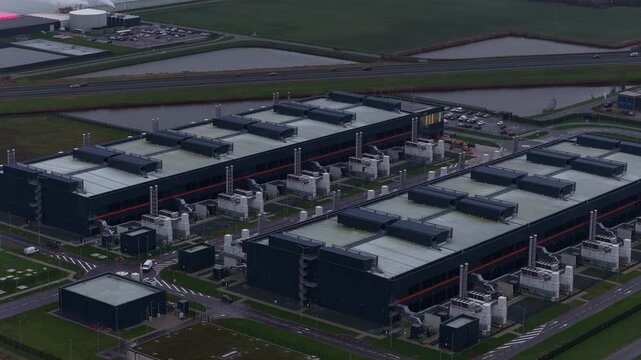 Aerial drone video of a large redundant colocation data center in Middenmeer, The Netherlands, showcasing massive data processing, storage capacity, and advanced AI computing infrastructure.