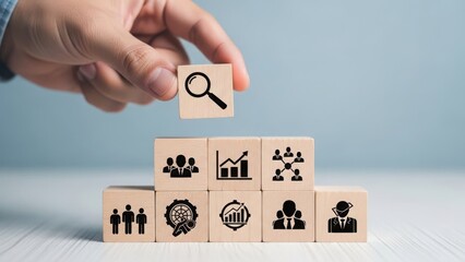 Hand holding magnifying glass over wooden blocks