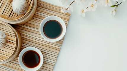 Soy sauce bowls with dim sum and bamboo steamer in overhead view