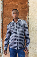 village happy african man portrait, outdoors in the nature ,at home wall behind