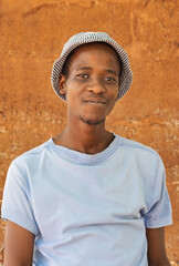 village happy african young man portrait, outdoors in the nature ,at home wall behind