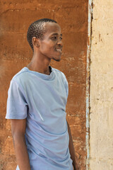 village happy african young man portrait, outdoors in the nature ,at home wall behind