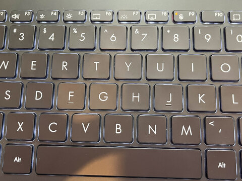 Close-up of a modern backlit laptop keyboard with black chiclet keys.