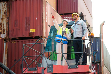 Workers inspecting containers at a cargo port, one pointing and discussing, highlighting logistics and transportation