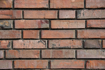 Obraz premium Textured red brick wall with varying shades and patterns, showcasing the rustic charm and durability of traditional masonry in architectural design and construction