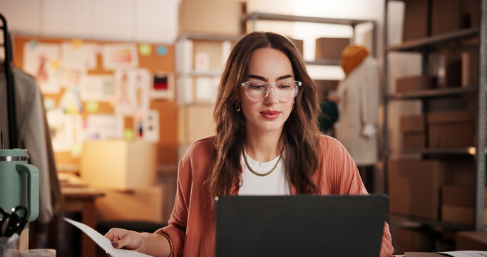 Woman, laptop and document for dropshipping, fashion and sales report at online shopping startup. Person, entrepreneur and designer with computer, ecommerce and admin with shipping schedule at studio - Powered by Adobe