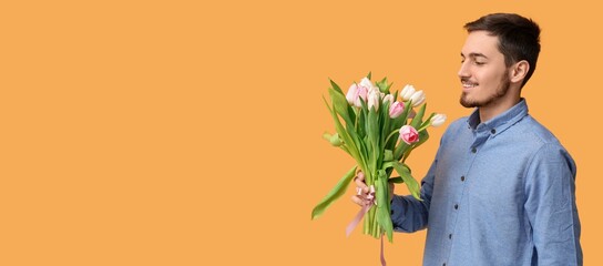 Young man with bouquet of beautiful tulips on yellow background with space for text