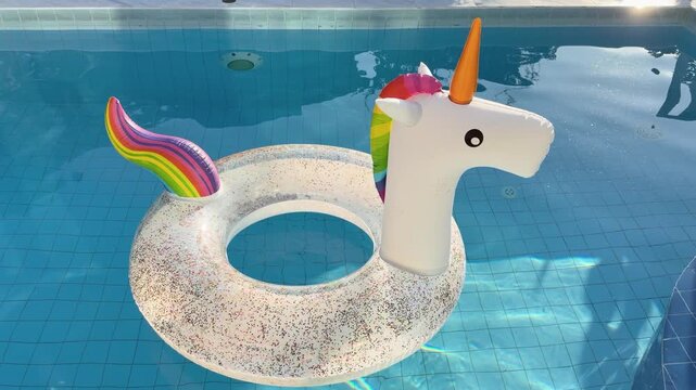 Rainbow Unicorn Pool Float Gently Bobbing in Sunlit Water