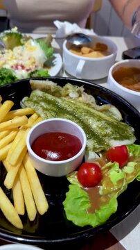 Fish Steak with Fries and Salad in Restaurant