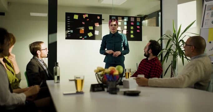 Business team meets in office to discuss plans and ideas with interactive presentation by a man in casual clothes in the afternoon