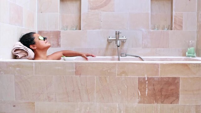 Relaxing woman enjoying a beauty treatment bath at home