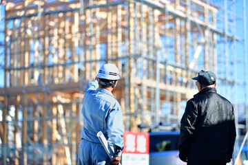 住宅建築の建て主と打ち合わせする工事監督