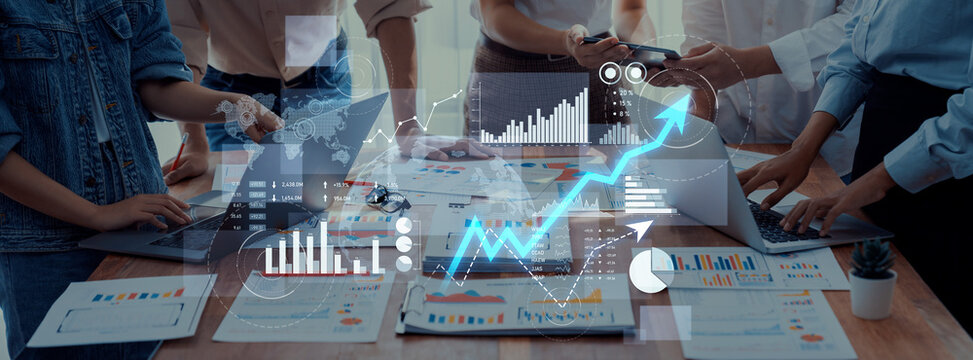 A dynamic team collaborates in a modern office setting with digital interfaces displaying financial graphs and analytics, emphasizing strategic growth and innovative ideas. Scalp - Powered by Adobe