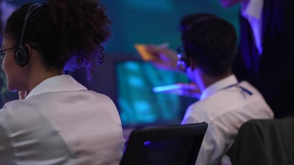 Professional technical support team managing customer service in a high-tech data center. Operators handling client communications and troubleshooting issues using digital interfaces during a night sh - Powered by Adobe