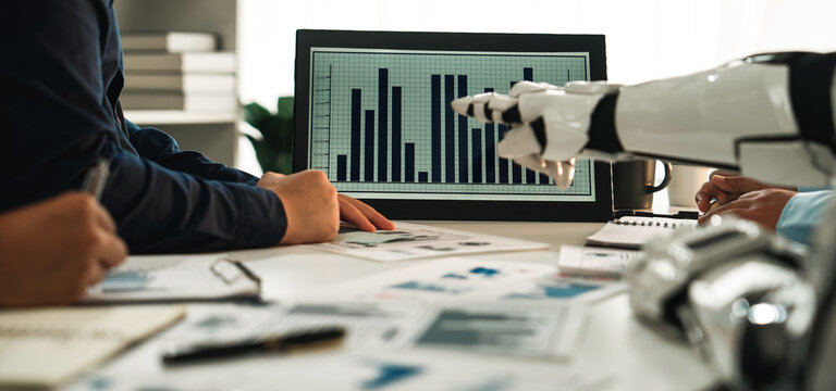 A dynamic office scene showcasing teamwork, where individuals collaborate with futuristic robotic technology and data analytics to drive business strategies effectively.Noogenesis - Powered by Adobe