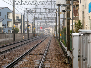 Fototapeta premium 雨が降る住宅街を通る能勢電鉄妙見線の線路