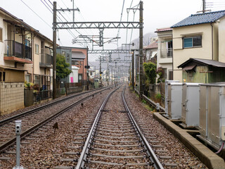 Fototapeta premium 雨が降る住宅街を通る能勢電鉄妙見線の線路