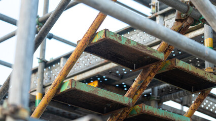 Scaffolding structure with stairway for going to higher floor for working at height such as the roof top. Industrial building and construction site workplace.