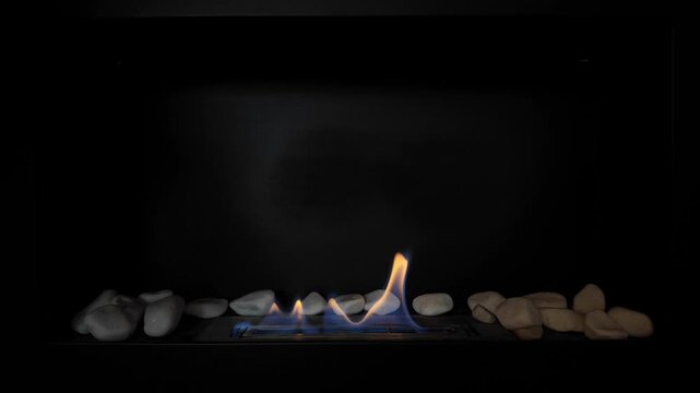 Bio ethanol fireplace with natural flame on black background decorative stones modern interior home design