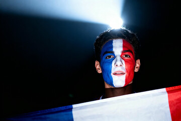 A determined sports fan, patriotically adorned with his country's flag and face paint, stands confidently under a spotlight. Evoking pride and devotion.