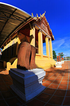 The beauty of Wat Thammamun Worawihan. In front of the ordination hall is a sandstone sema stone decoration. On the side is a view of green rice fields, Chai Nat Province, Thailand